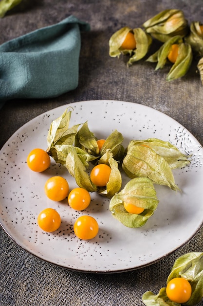 Fruta madura uchuva en un plato Nutrición vitamínica exótica Vista vertical