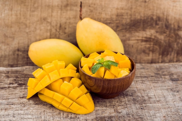 Fruta de mango y cubos de mango en la mesa de madera