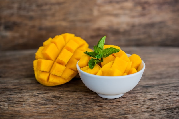 Fruta del mango y cubos de mango en la mesa de madera.