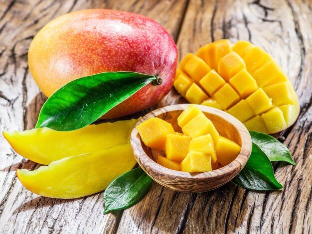 Fruta de mango y cubos de mango en la mesa de madera