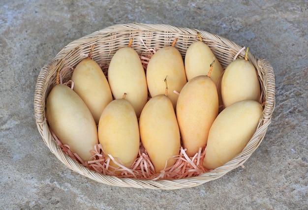 Fruta de mango dorado en cesta de mimbre. Mango Barracuda amarillo maduro. Fruta tropical en Tailandia.