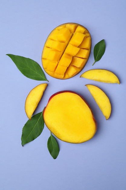 Fruta de mango maduro sabroso en superficie violeta