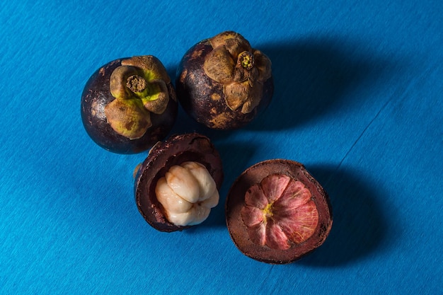 Fruta del mangostán sobre fondo azul con vista superior