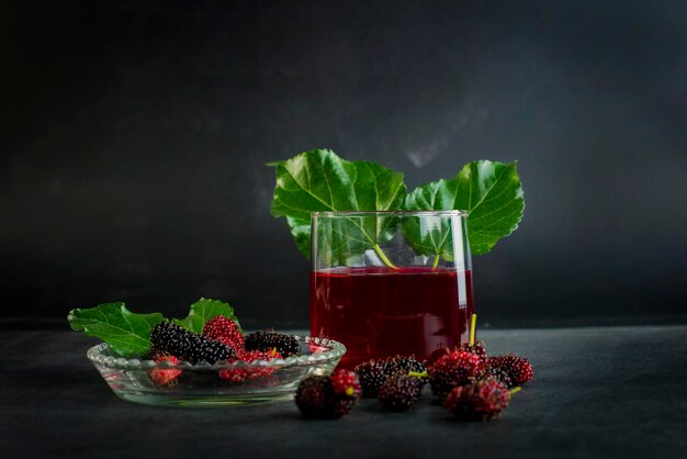 Foto fruta de morera fresca en un cuenco y jugo en un vaso