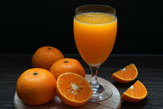 Fruta naranja fresca hace jugo de naranja en un vaso