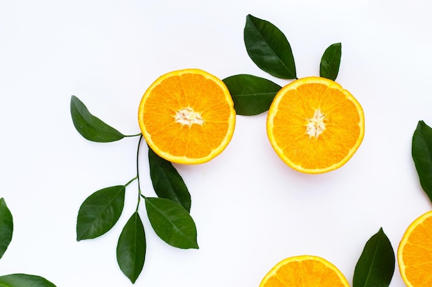 Fruta naranja con hojas verdes sobre fondo blanco.