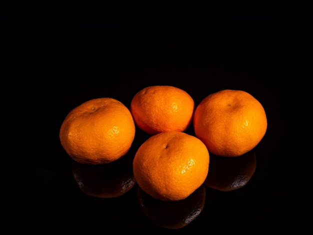 Fruta naranja mandarina sobre un fondo negro