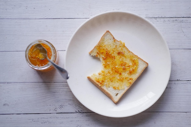 Fruta naranja untada en un pan en la mesa