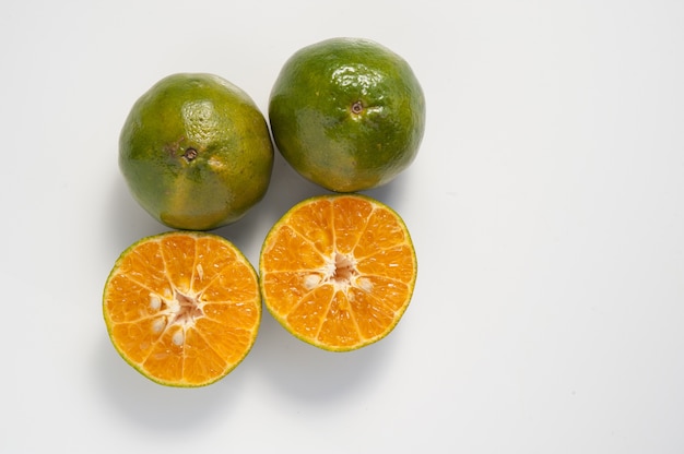 Foto fruta naranja verde sobre fondo blanco.