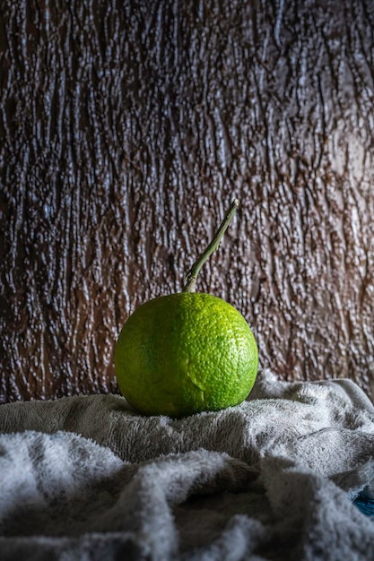 Fruta naranja verde sobre un fondo marrón