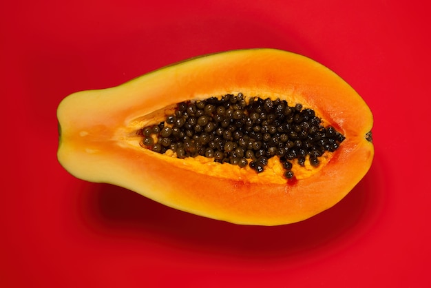 Fruta de papaya sobre un fondo naranja. Fruta tropical. Media papaya.