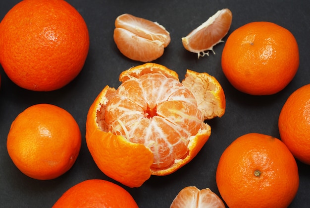 Foto fruta pelada de la mandarina en la tabla oscura aislada.