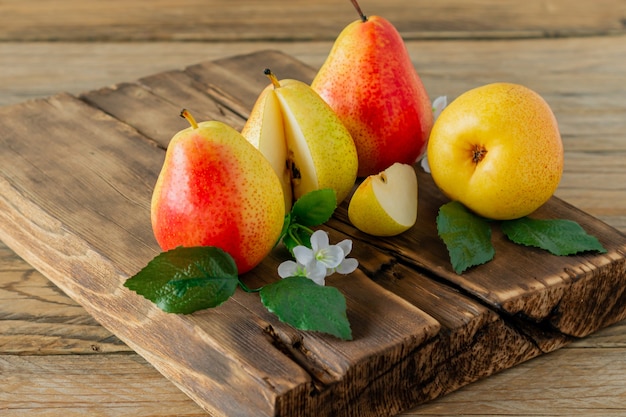 Fruta de peras maduras. Pera orgánica cosechada en tabla de cortar sobre mesa de madera. Cosecha de otoño.