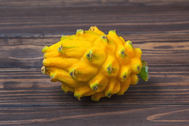 Fruta pitahaya amarela madura, deitada sobre um fundo de tábuas de madeira