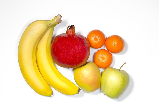 Fruta, plátano, manzana, granada, mandarina, mentira sobre un fondo blanco, naturaleza muerta