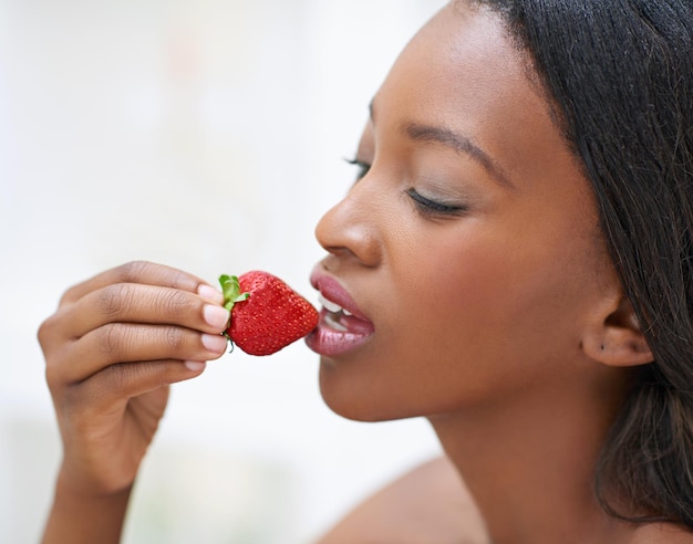 La fruta prohibida Disparo de una hermosa joven comiendo fresas