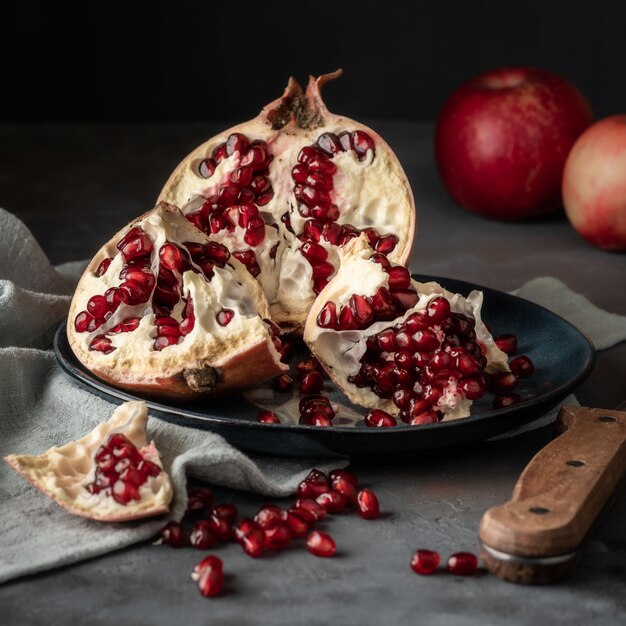 Fruta romã rasgada em um fundo escuro