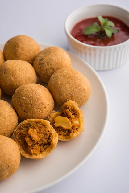 La fruta seca Kachori es una bola pequeña y redonda rellena con masala y anacardo, etc., servida con salsa de tomate y té caliente, producto Haldiram.