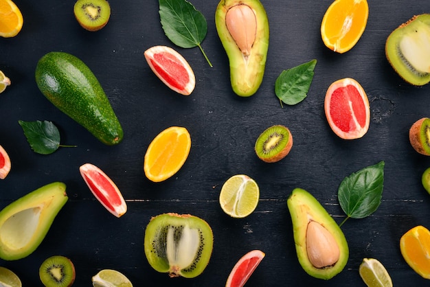 Fruta sobre un fondo de madera Aguacate lima naranja pomelo y kiwi Vista superior Espacio libre para su texto