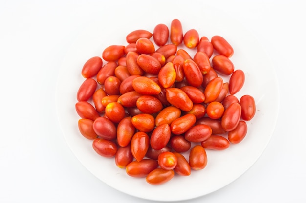 Fruta del tomate de cereza aislada en el plato blanco