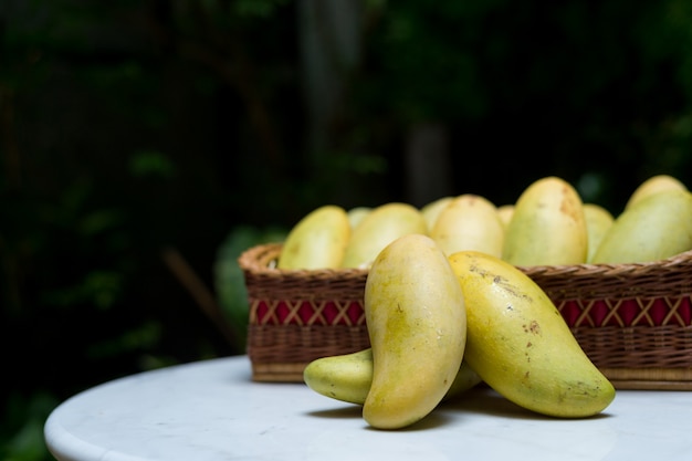 Fruta tropical de mango en canasta de madera