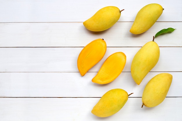 Fruta tropical, mango sobre fondo blanco de madera.