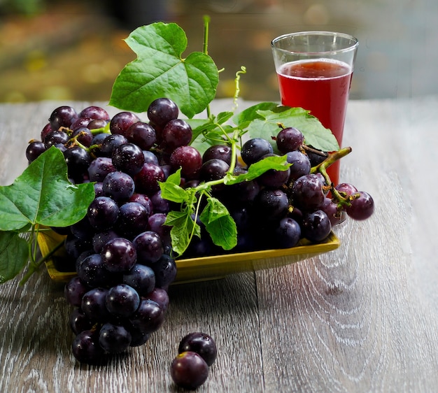 Fruta de uva y vino de uva en el fondo de madera