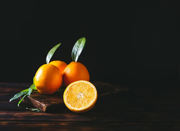 Frutas alaranjadas inteiras e cortadas em uma mesa de madeira rústica