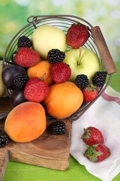 Frutas y bayas maduras en la mesa sobre fondo brillante