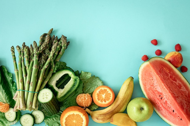 Frutas, bayas y verduras sobre un fondo azul.