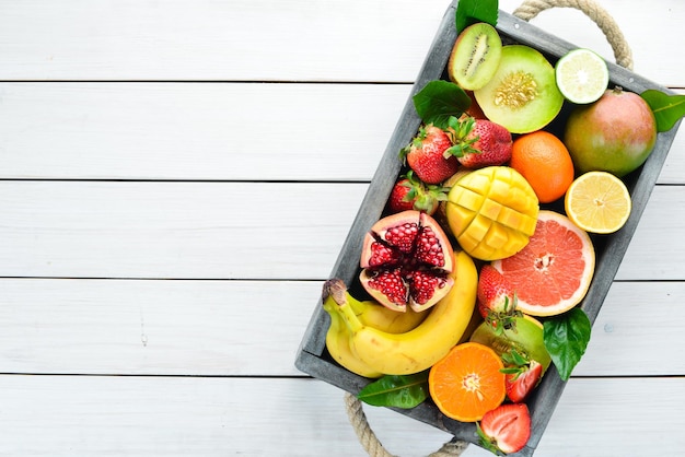 Frutas en una caja de madera Cítricos melón granada fresa plátano Vista superior Espacio libre para su texto