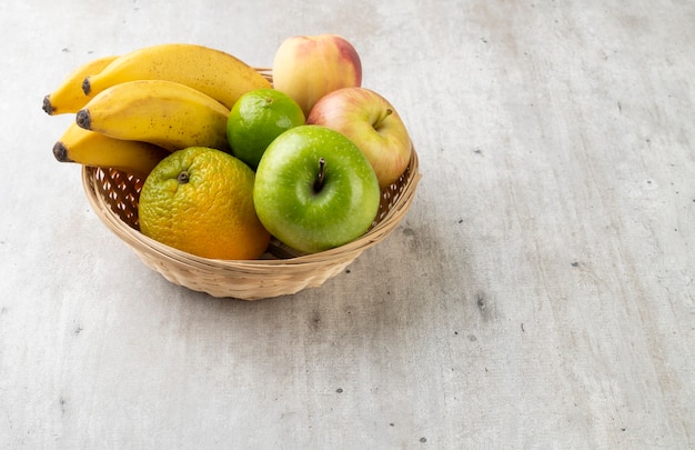 Frutas en una canasta sobre la mesa con espacio de copia.