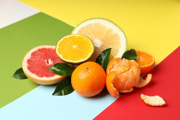 Frutas cítricas com folhas em fundo multicolorido