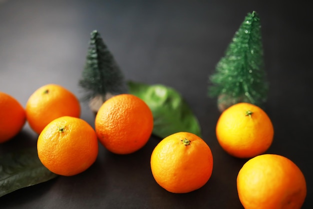 Frutas cítricas em um fundo cinza Tangerinas com folhas de frutas de Natal