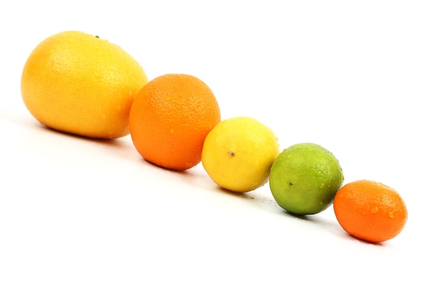 Frutas cítricas en una fila, inclinada sobre un fondo blanco.