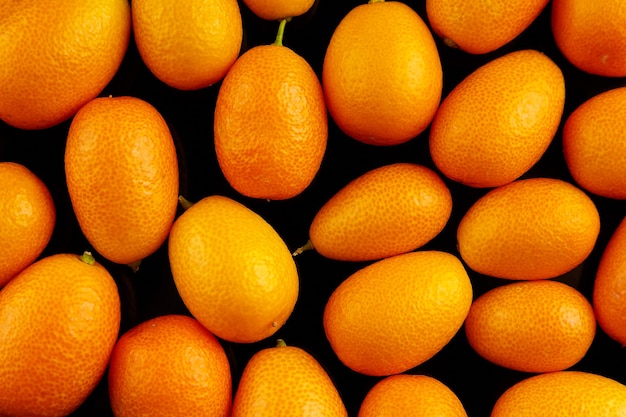 Frutas cítricas frescas de Kumquats em vista superior do fundo preto