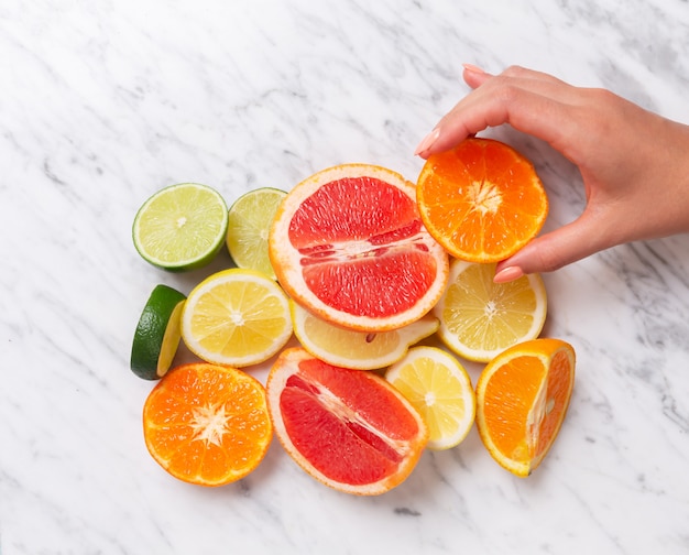 Frutas cítricas. Naranja, limón, pomelo, mandarina y lima sobre un fondo de piedra de moda