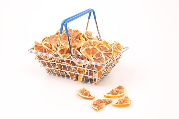 Frutas cítricas secas en una canasta sobre un fondo blanco. Alimentos vitamínicos