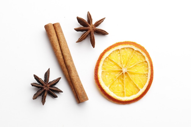 Frutas cítricas secas com canela, anis estrelado em fundo branco. ingredientes para vinho quente