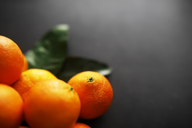 Frutas cítricas sobre un fondo gris Mandarinas con hojas Fruta de Navidad