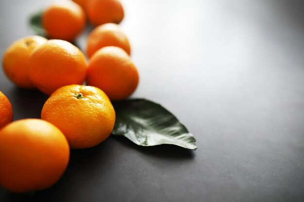 Frutas cítricas sobre un fondo gris Mandarinas con hojas Fruta de Navidad