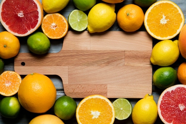 Frutas cítricas toranja limão limão laranja em um fundo de madeira rústico