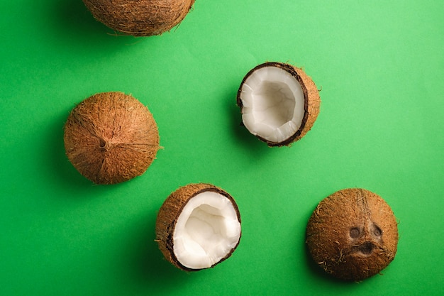 Foto frutas de coco sobre fondo verde liso, concepto tropical de comida abstracta, vista superior