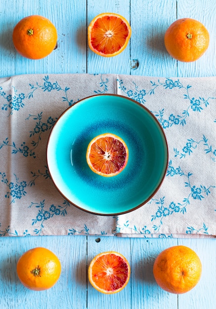 Frutas coloridas de laranja sobre uma mesa de madeira pintada de azul claro