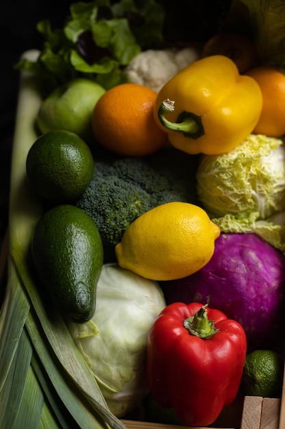 Frutas coloridas e vegetais maduros em uma caixa de madeira