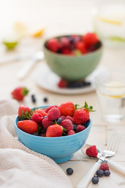 Frutas de bagas misturadas em uma tigela de frutas colocada em tecido branco