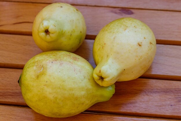 Frutas de goiaba inteiras na mesa de madeira