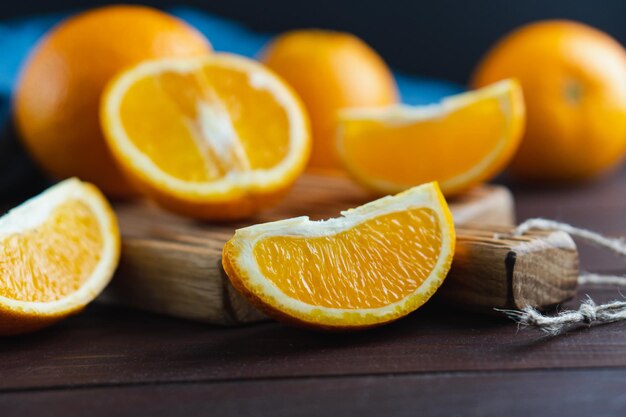 Frutas de laranjas fatiadas perto de têxteis de denim na placa de madeira Conceito mínimo de frutas cítricas de laranja suculenta