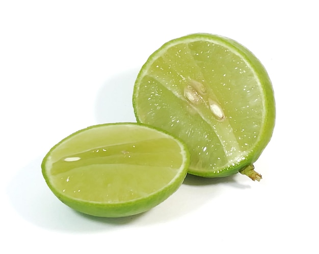 Frutas de limão verde espremidas na hora, fundo branco, foto retocada
