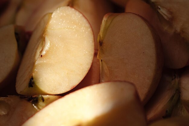 Frutas de maçãs fatiadas. Tiro macro de raio de sol brilhante cai em fatias de maçã sombreadas